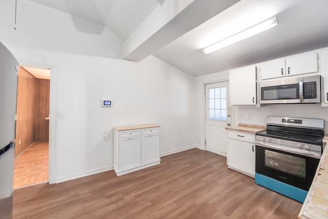 kitchen featuring light countertops, lofted ceiling, light wood-style flooring, white cabinets, and stainless steel appliances