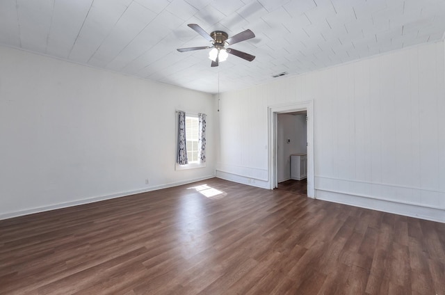 spare room with visible vents, baseboards, dark wood-style floors, and a ceiling fan