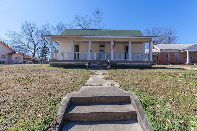 bungalow-style house featuring roof with shingles, a porch, and a front lawn