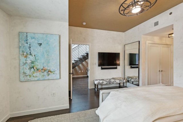 bedroom with visible vents, wood finished floors, and baseboards