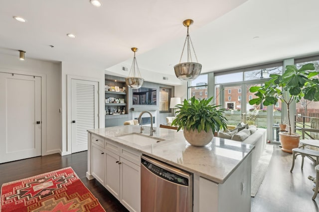 kitchen with a sink, stainless steel dishwasher, open floor plan, dark wood-style floors, and white cabinetry