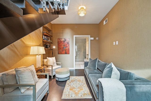 living area featuring visible vents, baseboards, and wood finished floors