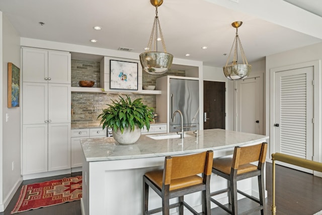 kitchen with visible vents, light stone countertops, a breakfast bar area, decorative backsplash, and open shelves