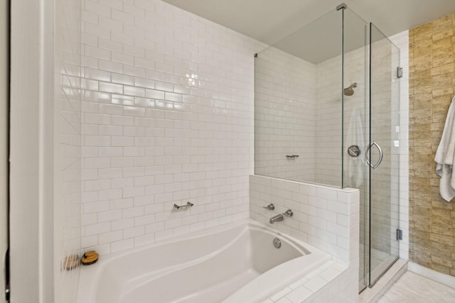 bathroom featuring a bath and a shower stall