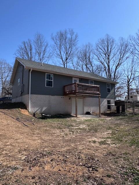 back of property featuring brick siding and a deck