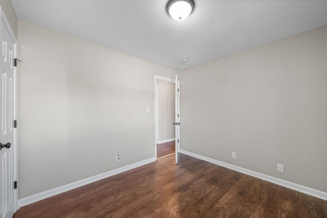 unfurnished room featuring wood finished floors, baseboards, and a textured ceiling