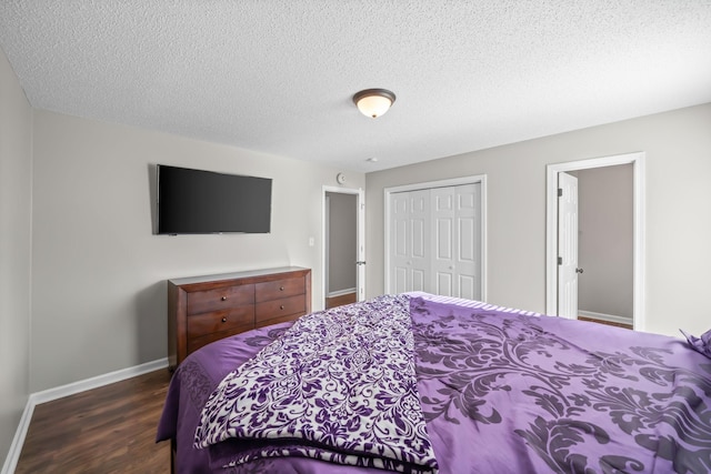 bedroom featuring a closet, baseboards, a textured ceiling, and wood finished floors