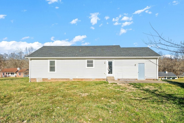 rear view of house featuring a yard and roof with shingles