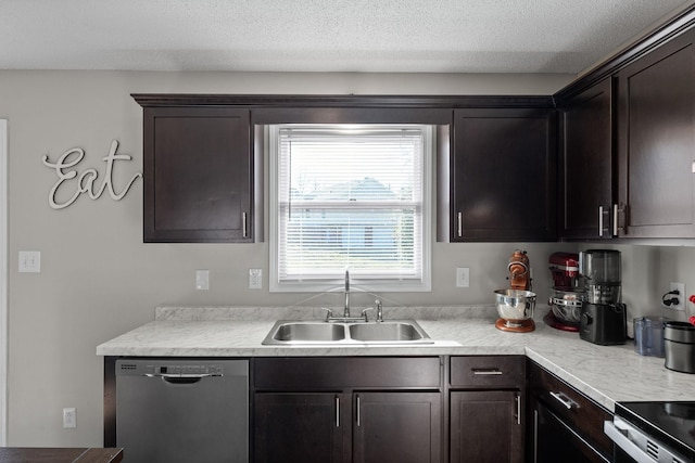 kitchen with appliances with stainless steel finishes, a textured ceiling, light countertops, and a sink