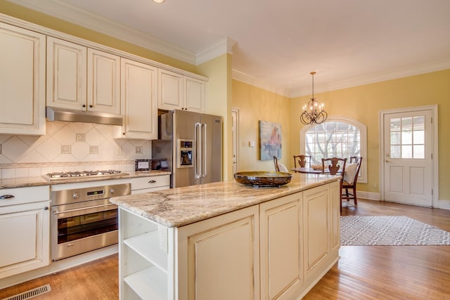 kitchen featuring visible vents, a notable chandelier, light wood-style flooring, under cabinet range hood, and stainless steel appliances