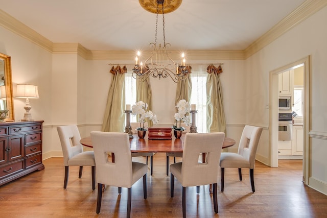 dining space with a chandelier, baseboards, wood finished floors, and crown molding