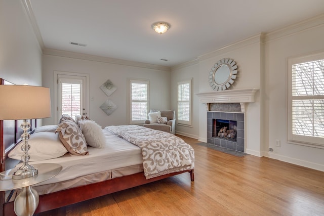 bedroom with visible vents, multiple windows, ornamental molding, and wood finished floors