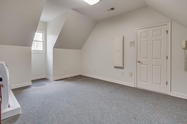 bonus room featuring baseboards, visible vents, and dark colored carpet