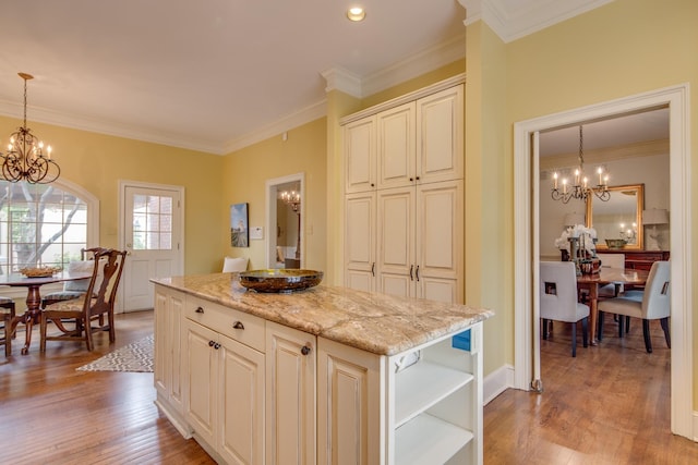 kitchen with open shelves, light stone counters, a notable chandelier, and light wood-style flooring