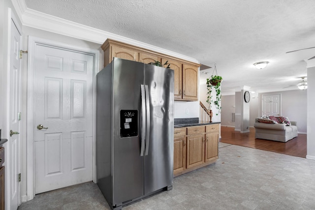 kitchen featuring dark countertops, open floor plan, stainless steel refrigerator with ice dispenser, a textured ceiling, and a ceiling fan