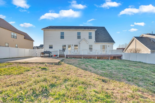 rear view of house with a patio, a yard, and a fenced backyard