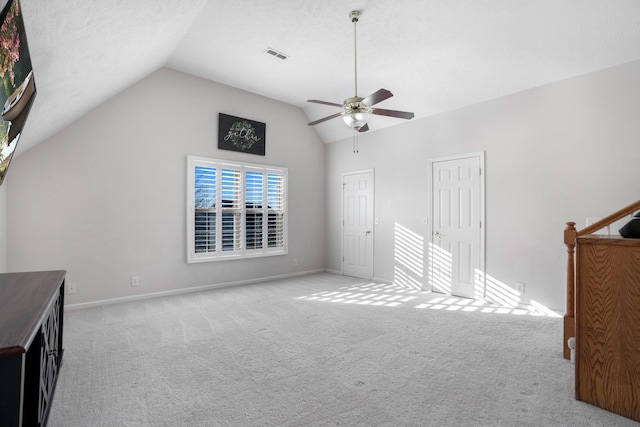 unfurnished bedroom featuring visible vents, lofted ceiling, light colored carpet, and baseboards