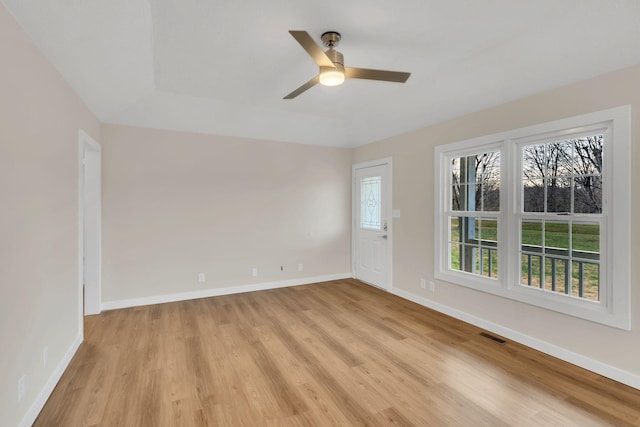 spare room with visible vents, light wood-style floors, baseboards, and ceiling fan