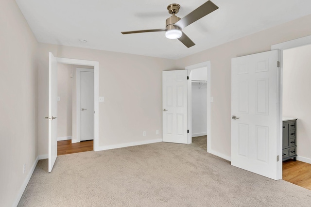 unfurnished bedroom featuring baseboards, a walk in closet, and carpet