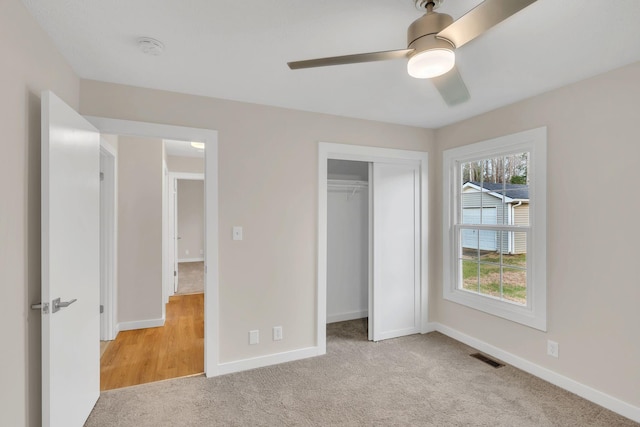 unfurnished bedroom featuring visible vents, ceiling fan, baseboards, light carpet, and a closet