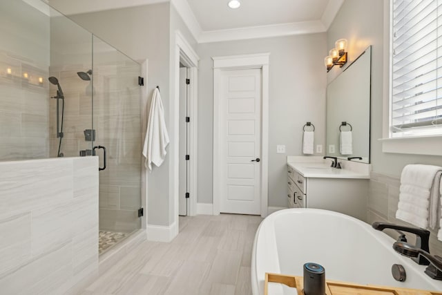 bathroom with ornamental molding, a shower stall, baseboards, a soaking tub, and vanity