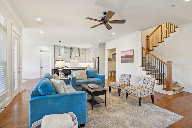 living area with crown molding, stairway, recessed lighting, and wood finished floors