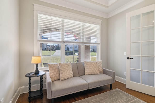 sitting room with a wealth of natural light, crown molding, baseboards, and wood finished floors