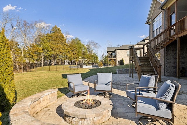 view of patio featuring stairs, a fire pit, and fence