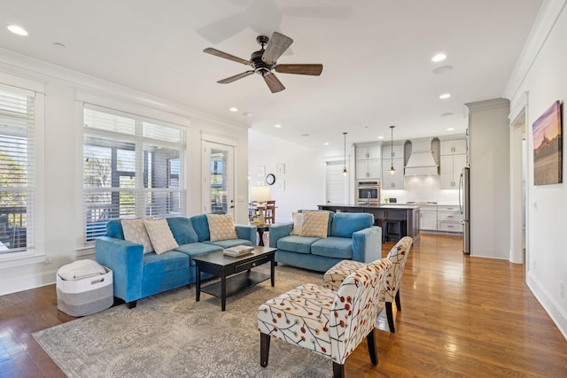 living room featuring wood finished floors, a wealth of natural light, and ornamental molding