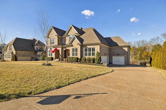 view of front of home with brick siding, a front lawn, an attached garage, and driveway