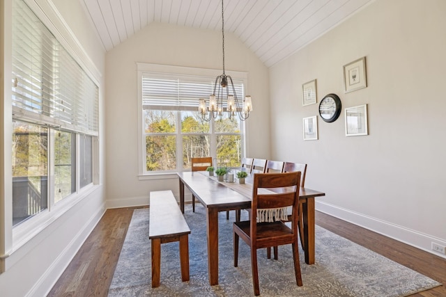 dining space with a notable chandelier, baseboards, dark wood-type flooring, and vaulted ceiling