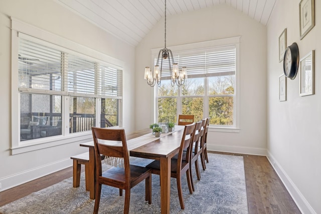 dining room featuring a healthy amount of sunlight, dark wood-type flooring, baseboards, and vaulted ceiling