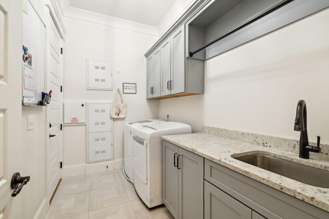 laundry area with a sink, cabinet space, separate washer and dryer, and ornamental molding