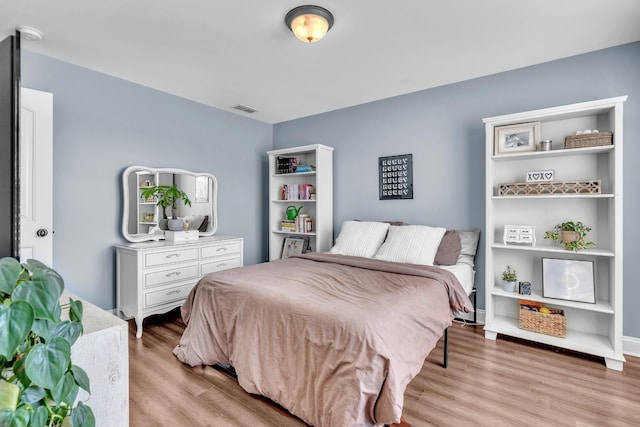 bedroom with visible vents and wood finished floors