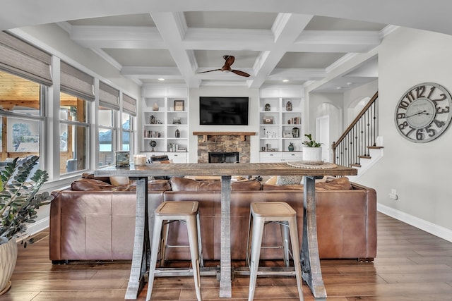 living room with a ceiling fan, wood finished floors, baseboards, coffered ceiling, and beam ceiling