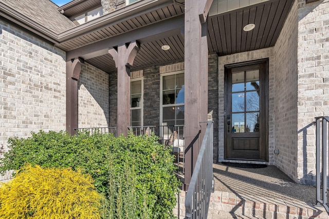 entrance to property featuring brick siding and a porch