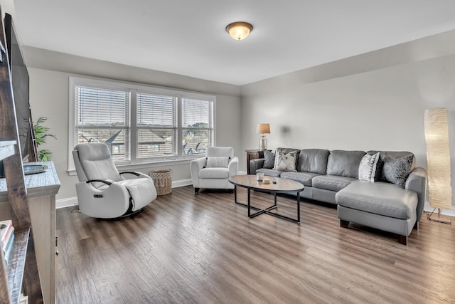 living area with baseboards and wood finished floors