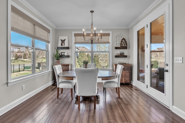 dining room with crown molding, baseboards, dark wood-type flooring, and an inviting chandelier