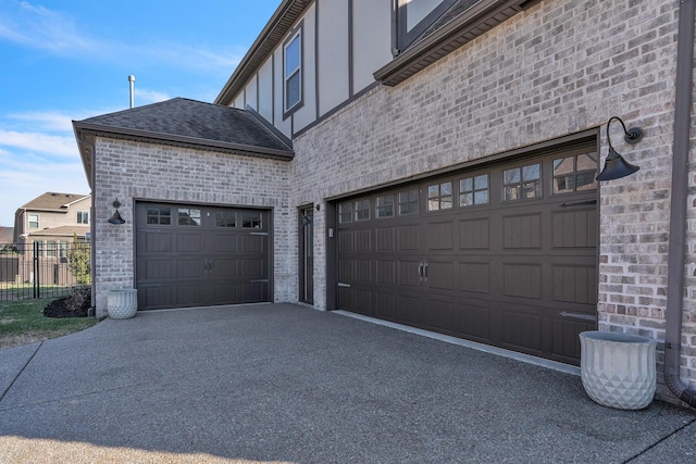 garage featuring aphalt driveway and fence