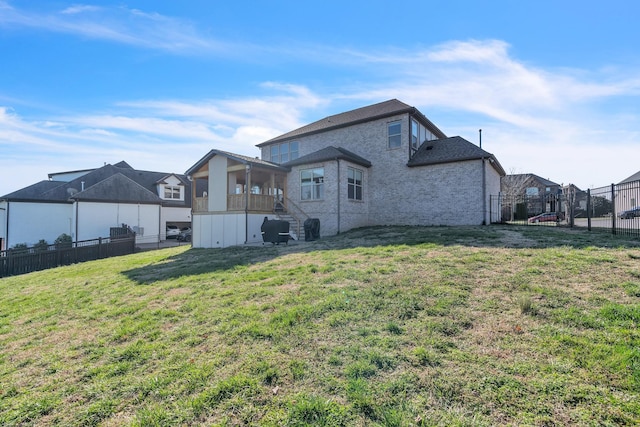 back of house featuring a yard and fence