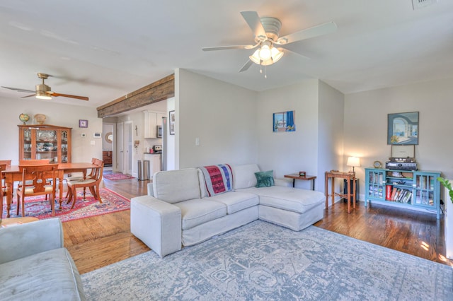 living area featuring visible vents, wood finished floors, and a ceiling fan