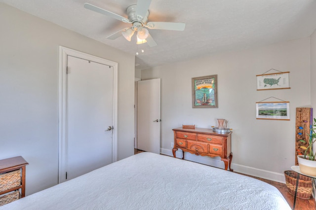 bedroom featuring wood finished floors, baseboards, and ceiling fan