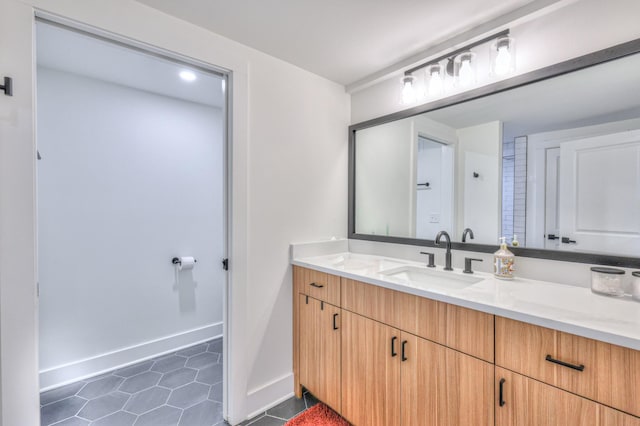 bathroom with tile patterned floors, vanity, and baseboards