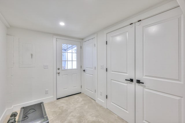 doorway featuring light carpet and baseboards