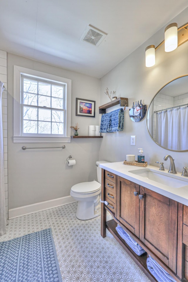 bathroom with vanity, a shower with shower curtain, baseboards, visible vents, and toilet