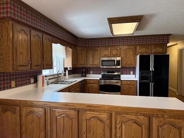 kitchen with tasteful backsplash, light countertops, a peninsula, stainless steel appliances, and a sink