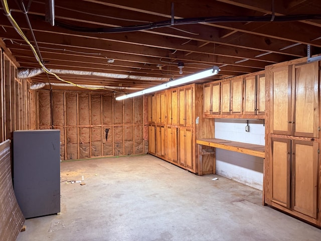 unfinished basement featuring fridge