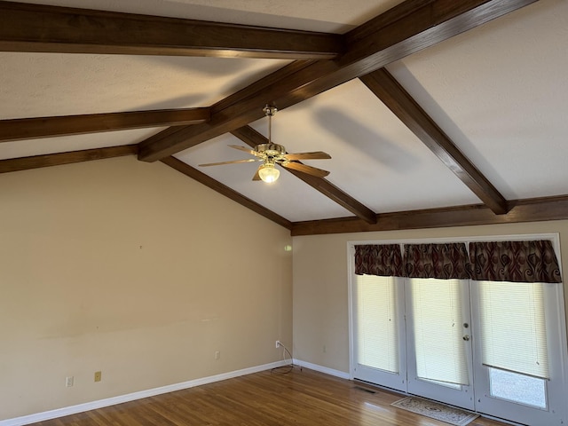 empty room featuring visible vents, ceiling fan, baseboards, dark wood finished floors, and lofted ceiling with beams