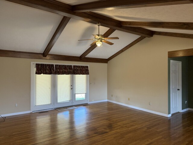 empty room featuring a ceiling fan, visible vents, wood finished floors, baseboards, and vaulted ceiling with beams