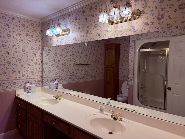 bathroom with wallpapered walls, toilet, and a sink